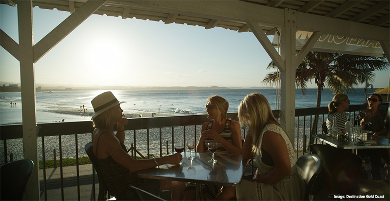 People sitting in a cafe overlooking the beach Destination Gold Coast